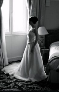 regard d'une future mariée à travers une fenêtre, comme pour se poser la question concernant son futur mariage